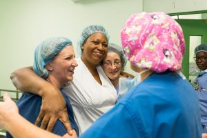 employees hugging and smiling after eye operation