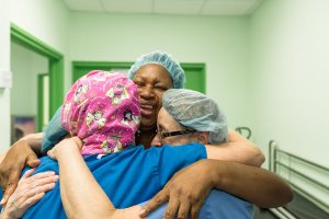 employees hugging and laughing after eye operation