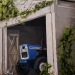 painting of blue tractor in shed with grey tabby cat